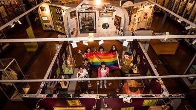 Aerial view of people in Lynn museum holding a Pride flag